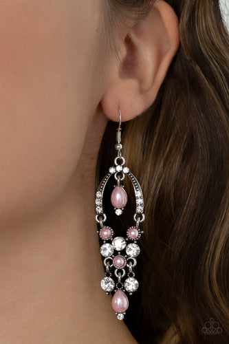 Glittery white rhinestones and pearly pink beaded fittings delicately swing from the bottom of an ornately embellished oval frame. A matching pearly frame dangles from the top of the decorative silver frame, adding timeless movement to the sparkly display. Earring attaches to a standard fishhook fitting.  Sold as one pair of earrings.