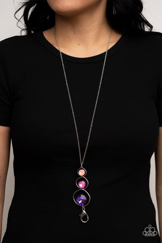 A sparkly ombré of opalescent coral, pink, and purple gems adorn the bottoms of three silver hoops that gradually increase in size as they stack into an asymmetrical pendant. The glowing pendant swings from the bottom of a lengthened silver chain, creating a stellar centerpiece. A lobster clasp hangs from the bottom of the design to allow a name badge or other item to be attached. Features an adjustable clasp closure.  Sold as one individual lanyard. Includes one pair of matching earrings.