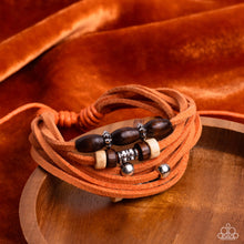 Load image into Gallery viewer, An earthy assortment of silver beads, textured silver accents, and brown and white wooden beads glides along layered strands of rustic orange suede, resulting in a whimsically layered centerpiece. Features an adjustable sliding knot closure.  Sold as one individual bracelet.
