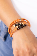 Load image into Gallery viewer, An earthy assortment of silver beads, textured silver accents, and brown and white wooden beads glides along layered strands of rustic orange suede, resulting in a whimsically layered centerpiece. Features an adjustable sliding knot closure.  Sold as one individual bracelet.
