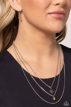 Load image into Gallery viewer, Three mismatched silver chains layer across the chest. Dotted in a dainty iridescent rhinestone, a shiny silver charm swings from the uppermost chain above a solitaire orange rhinestone for a twinkly finish. Features an adjustable clasp closure.  Sold as one individual necklace. Includes one pair of matching earrings.
