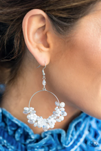 Load image into Gallery viewer, A timeless collection of iridescent crystal-like accents, dainty white pearls, and white floral frames delicately cluster along the bottom of a silver hoop, creating a glamorous glow. The earring attaches to a standard fishhook fitting.  Sold as one pair of earrings.

