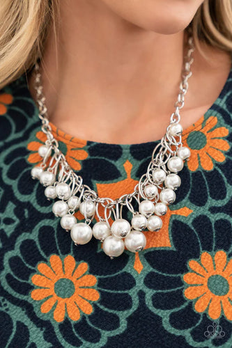 Oversized white pearls dance from the bottoms of shiny silver ovals that delicately cluster along a chunky silver chain, resulting in a luxurious fringe below the collar. Features an adjustable clasp closure.  Sold as one individual necklace. Includes one pair of matching earrings.