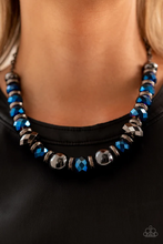 Load image into Gallery viewer, A dramatic assortment of oversized gunmetal beads, textured gunmetal rings, and faceted metallic blue gems delicately glides along an invisible wire below the collar, resulting in a stellar sparkle. Features an adjustable clasp closure.  Sold as one individual necklace. Includes one pair of matching earrings.
