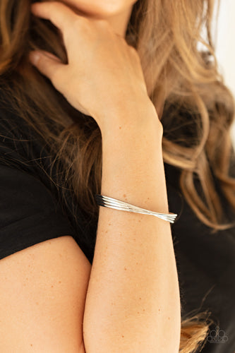 A stack of four glistening silver bars delicately twist at the center as they delicately layer into a dainty cuff around the wrist.  Sold as one individual bracelet.