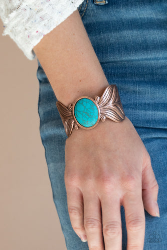 Etched and embossed in lifelike textures, two oversized copper feathers branch out from a refreshing turquoise stone center, curling into a whimsical cuff around the wrist.  Sold as one individual bracelet.