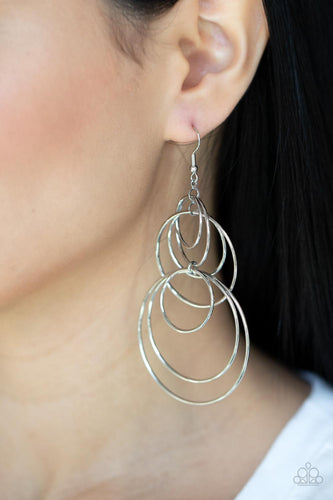 Varying in size, a shiny collection of mismatched silver hoops haphazardly connect into a dizzying lure. Earring attaches to a standard fishhook fitting.  Sold as one pair of earrings.