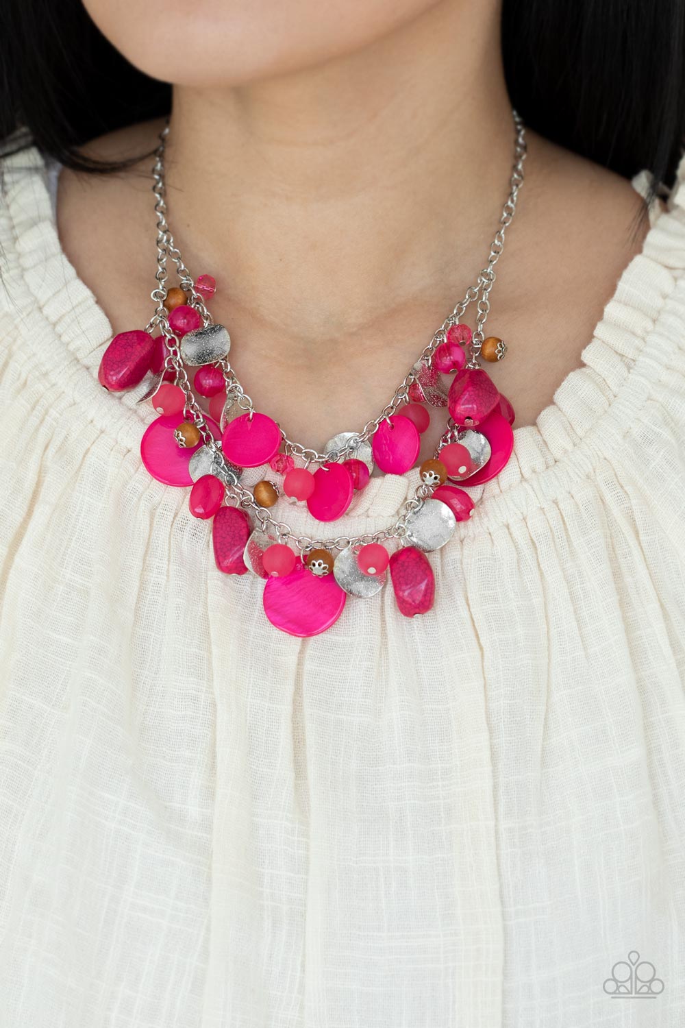 Infused with wooden beads and silver discs, an earthy collection of glassy, opaque, and shell-like Raspberry Sorbet beads swing from two silver chains. The vivacious display effortlessly layers below the collar, creating a springtime inspired fringe. Features an adjustable clasp closure.