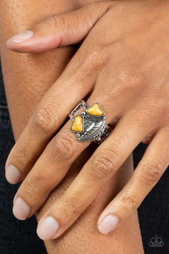 Asymmetrical yellow stones adorn the front of an antiqued silver frame adorned in a silver feather, creating a rustic centerpiece atop the finger. Features a stretchy band for a flexible fit.  Sold as one individual ring.