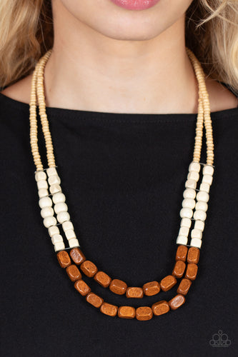 Varying in shape, size, and color, an earthy collection of tan, white, and brown wood beads are threaded along invisible wire across the chest, creating tropical inspired layers. Features an adjustable clasp closure.  Sold as one individual necklace. Includes one pair of matching earrings.