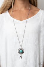 Load image into Gallery viewer, An oversized turquoise stone adorns the center of an antiqued silver frame radiating with silver studded and wire-like detail, creating an authentic artisan inspired pendant. A lobster clasp hangs from the bottom of the design to allow a name badge or other item to be attached. Features an adjustable clasp closure.  Sold as one individual lanyard. Includes one pair of matching earrings.
