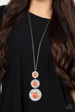 Load image into Gallery viewer, Mismatched emerald and oval cut burnt orange acrylic beads adorn the centers of scratched silver discs that gradually increase in size as they link at the bottom of a lengthened silver chain. The beads vary in faceted and smooth finishes, adding a trendy finish to the colorful talisman-like pendant. Features an adjustable clasp closure.  Sold as one individual necklace. Includes one pair of matching earrings.
