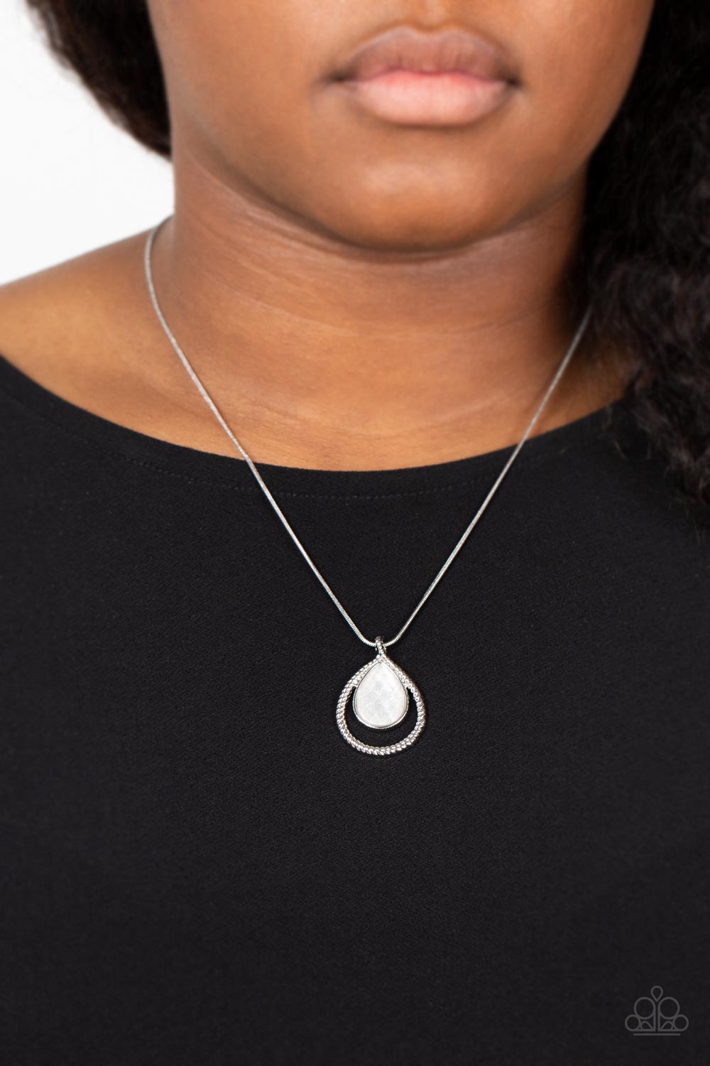 Infused with shimmering sparkle, a faceted white teardrop gem connects to the top of a textured silver teardrop frame, resulting in an enchanting pendant below the collar. Features an adjustable clasp closure.  Sold as one individual necklace. Includes one pair of matching earrings.