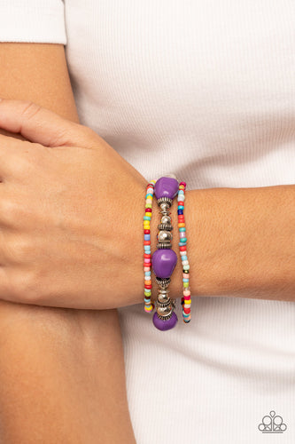 A pair of multicolored seed beaded stretchy bracelets joins a stretchy strand of shiny silver beads, textured silver accents, and faceted purple beads around the wrist, creating colorful layers.  Sold as one set of three bracelets.