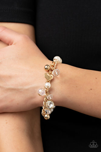 Mismatched gold beads, white pearls, crystal-like accents, gems and heart charms dance from a section of gold chain that attaches to a stretchy band of white pearls around the wrist for a flirtatious sparkle.  Sold as one individual bracelet.