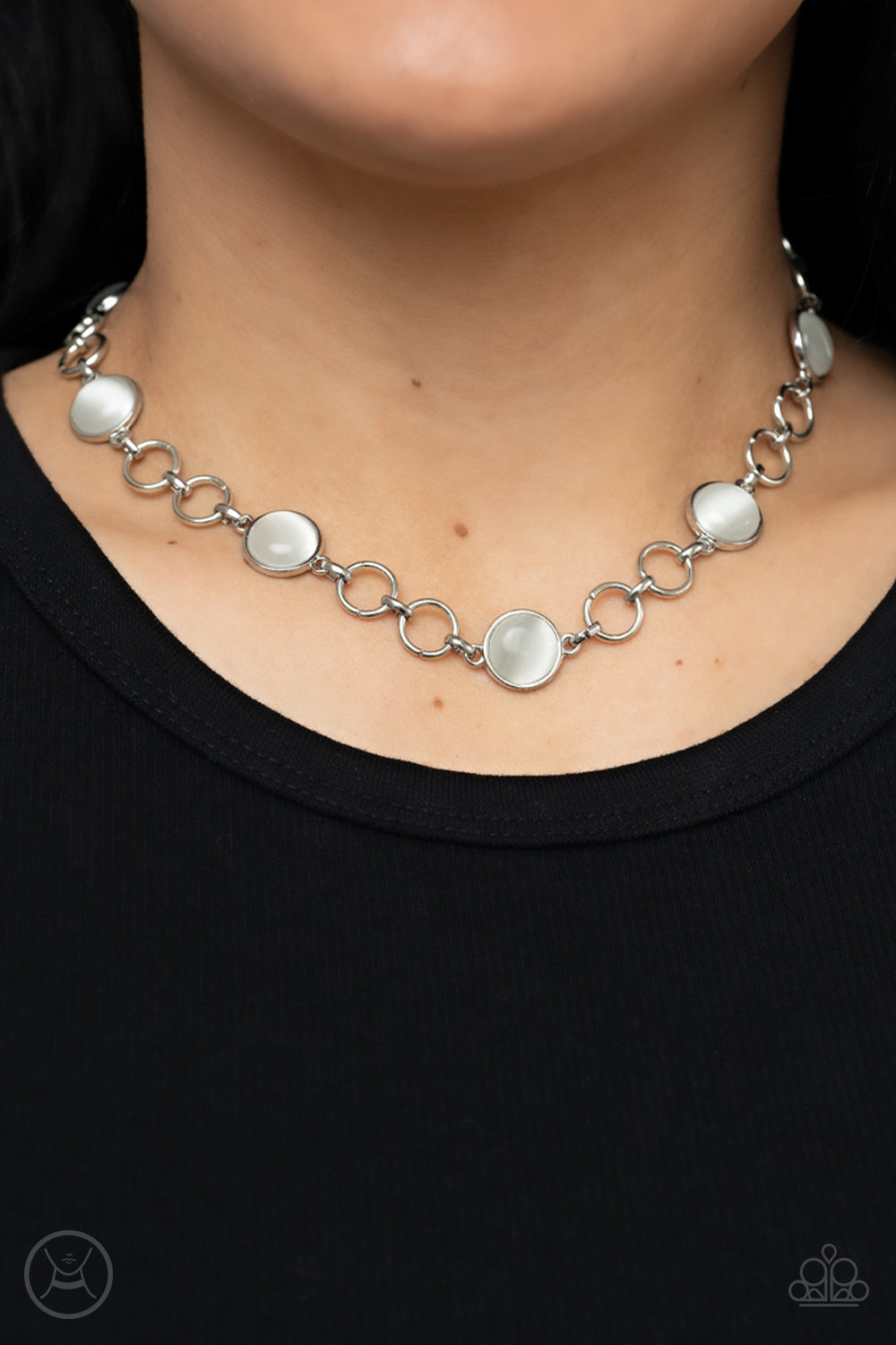 Pairs of silver hoops and white cat's eye dotted silver frames delicately link around the neck, creating a dreamy glow. Features an adjustable clasp closure.  Sold as one individual choker necklace. Includes one pair of matching earrings.