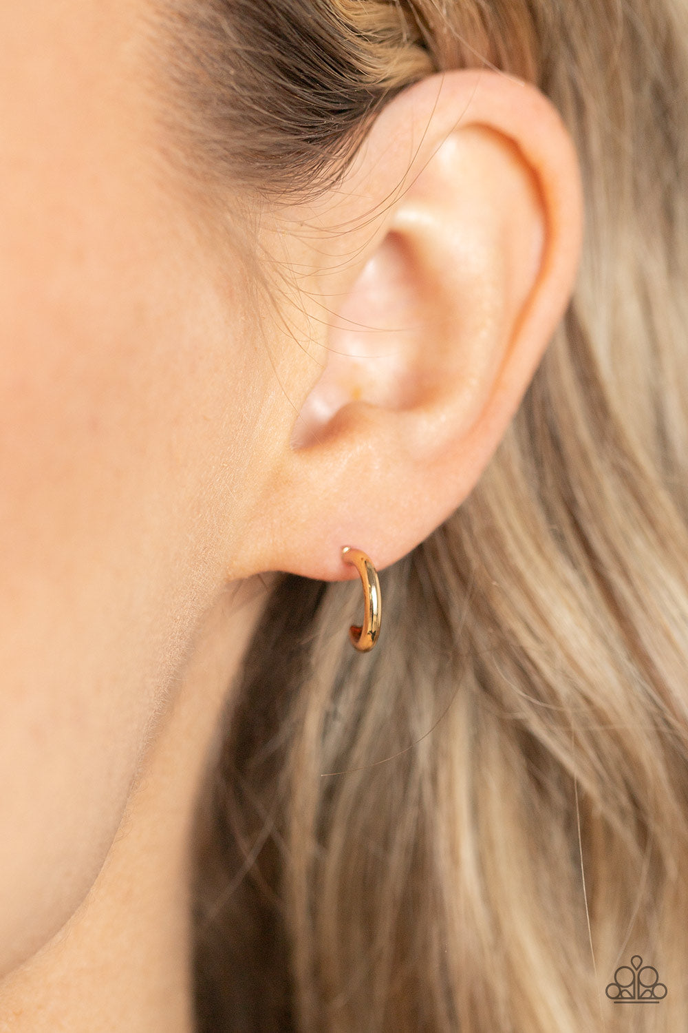 A glistening gold bar curves into a classic hoop, creating a dainty peek of shimmer. Earring attaches to a standard post fitting. Hoop measures approximately 1/2
