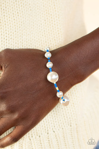 Irregular-shaped pearls in varying sizes are scattered amongst blue and yellow seed beads that are threaded along a wire, resulting in a refreshing and playful style around the wrist. Features an adjustable clasp closure.  Sold as one individual bracelet.