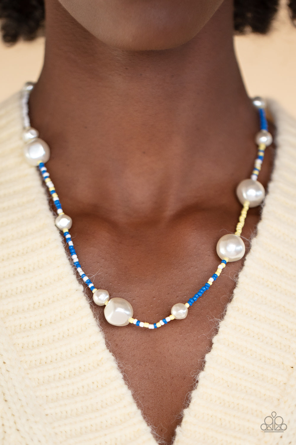 Irregular-shaped pearls in varying sizes are scattered amongst blue, yellow, and white seed beads that are threaded along a wire, resulting in a refreshing and playful style below the collar.  Sold as one individual necklace. Includes one pair of matching earrings.