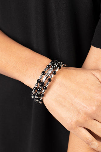 A mismatched collection of faceted silver beads, studded silver rings, and polished black beads are threaded along a wire that coils around the wrist, creating a colorful infinity wrap style bracelet.  Sold as one individual bracelet.