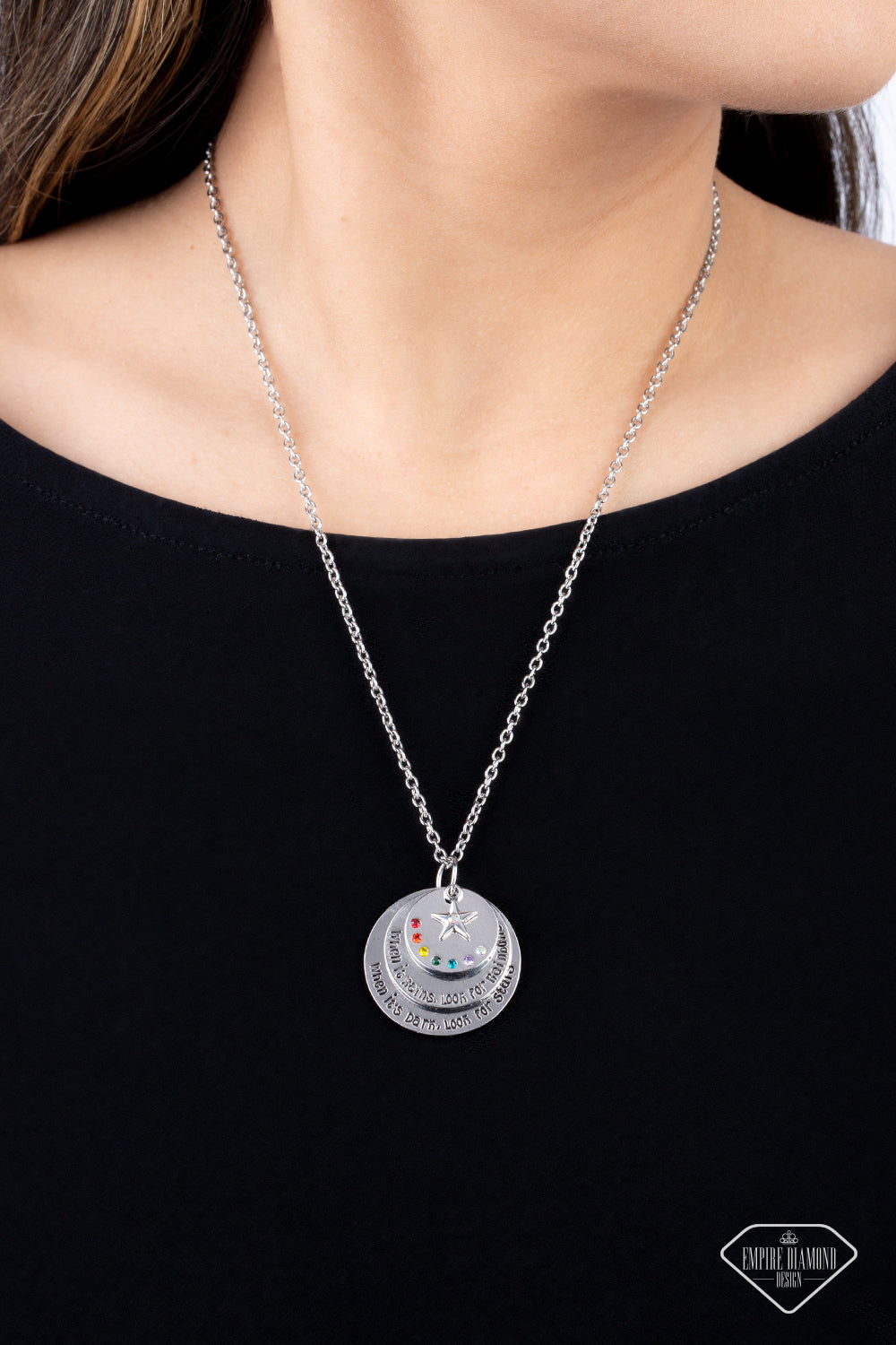 Dotted in a rainbow of dainty rhinestones, a shiny silver disc sits atop two overlapping silver discs that gradually increase in size. Sold as one individual necklace. Includes one pair of matching earrings.