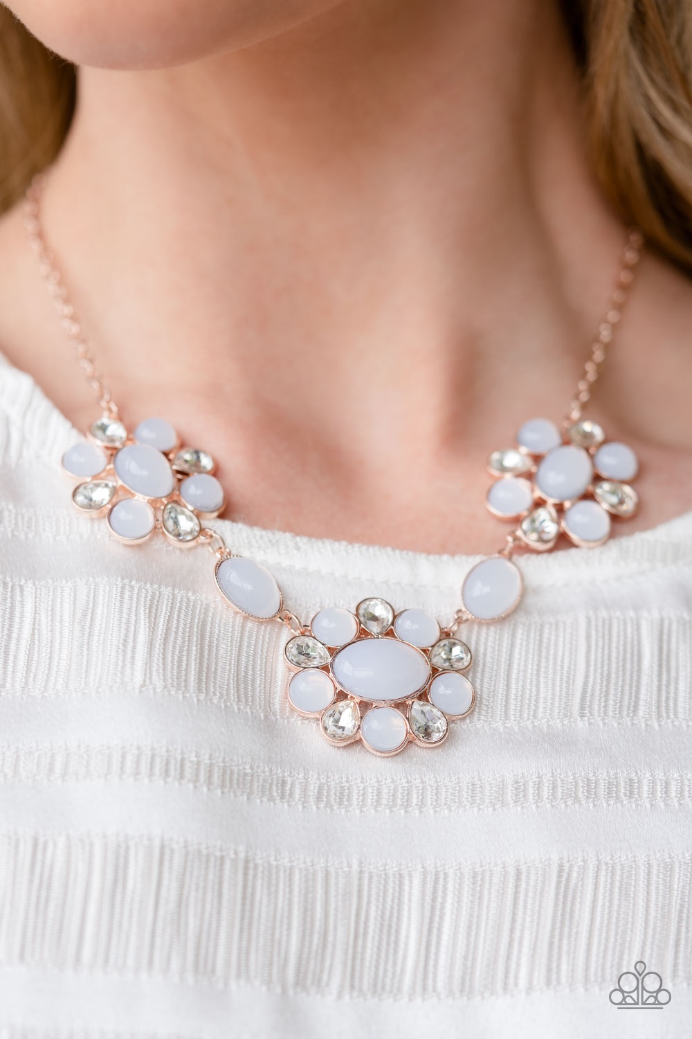 Brilliant, white, teardrop-shaped rhinestones, set in rose gold fittings, are set between glassy opalescent beads in the tranquil shade of white, wrapping around an oval bead in the same white tint to create three floral-inspired clusters.  Sold as one individual necklace. Includes one pair of matching earrings.