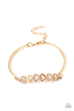 Load image into Gallery viewer, Gold, heart-shaped silhouettes are tilted on their sides, falling in line with variations of the same gold frames encrusted in white rhinestones. The alternating pattern of metallic sheen and glittery shimmer adds eye-catching detail, as the hearts connect into a curved pendant that curls around the wrist. Features an adjustable clasp closure.  Sold as one individual bracelet.
