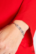 Load image into Gallery viewer, Silver, heart-shaped silhouettes are tilted on their sides, falling in line with variations of the same silver frames encrusted in white rhinestones. The alternating pattern of metallic sheen and glittery shimmer adds eye-catching detail, as the hearts connect into a curved pendant that curls around the wrist. Features an adjustable clasp closure.  Sold as one individual bracelet.
