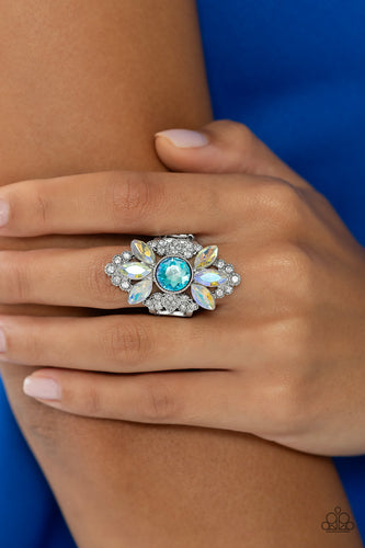 Exploding from the light blue surface, a trio of iridescent marquise-cut gems coalesces the top and bottom of the airy frame for additional eye-catching detail. Features a stretchy band for a flexible fit. Due to its prismatic palette, color may vary.  Sold as one individual ring.
