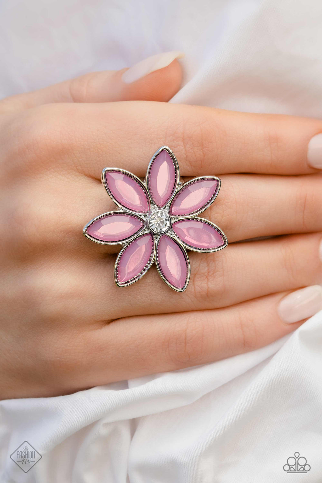 Glassy marquise-cut petals in a dreamy orchid hue, fan out around a sparkling white gem center, creating a vibrant, oversized flower that sits prominently atop the finger. Features a stretchy band for a flexible fit.  Sold as one individual ring.